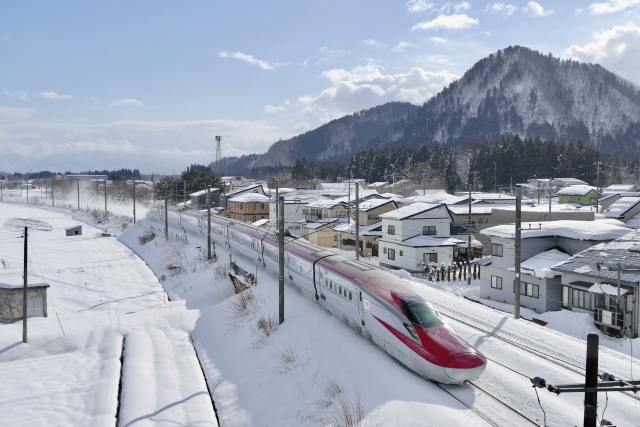 冬の大仙市内を通過する新幹線